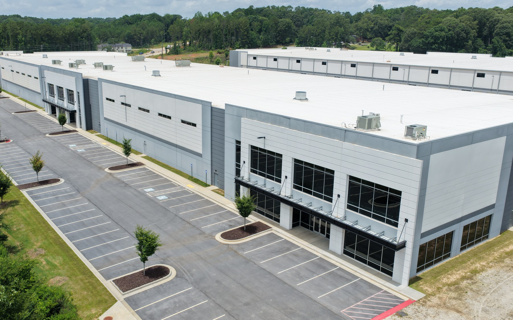 Aerial view of completed commercial buildings showing design, scale, parking, and surrounding context